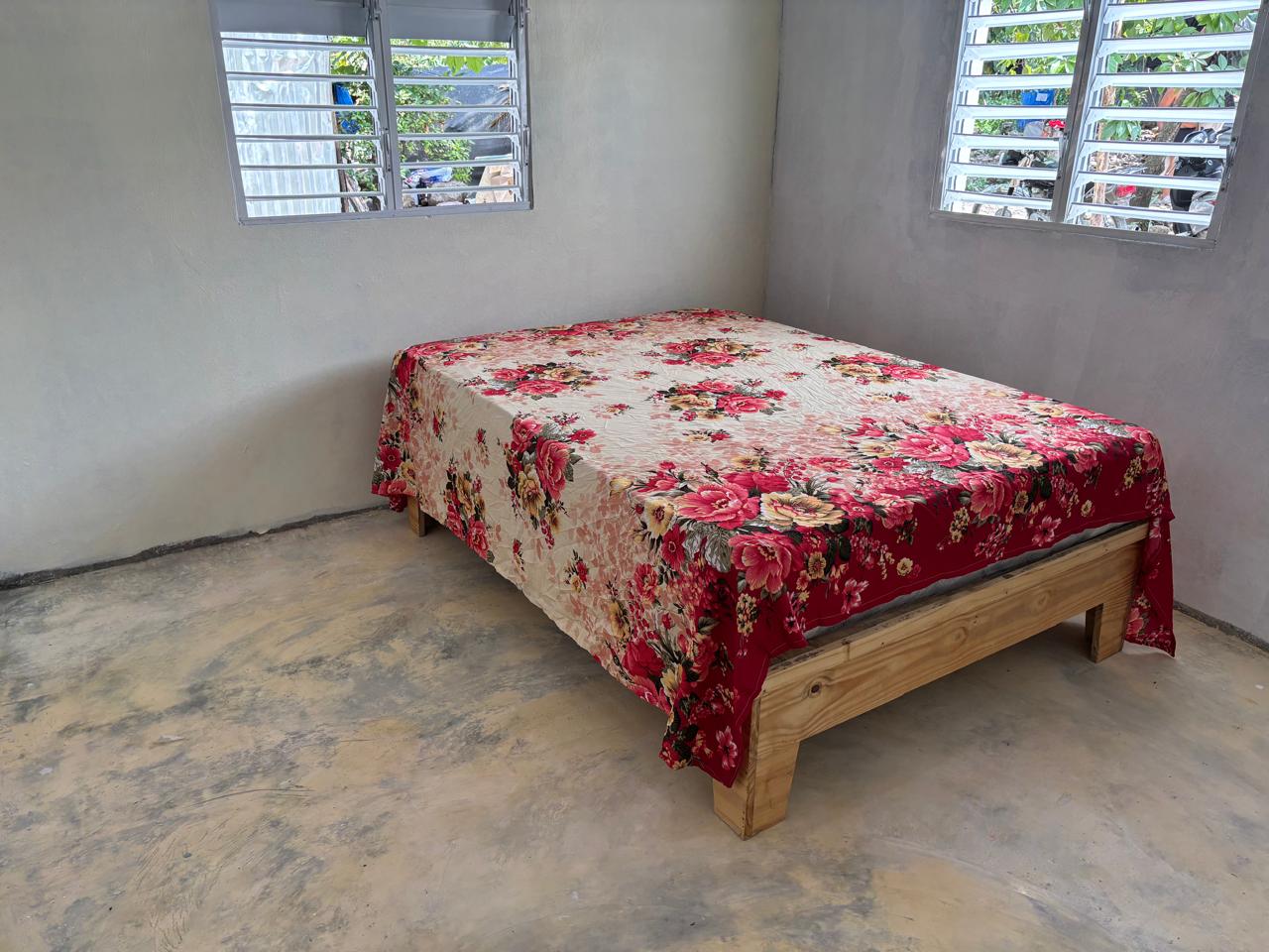 Nueva habitación con cama y piso de cemento pulido