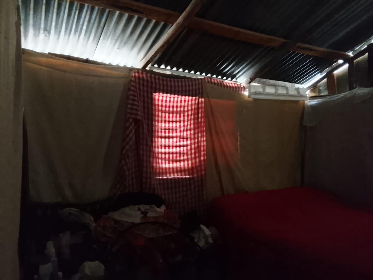 Dormitorio anterior, separado con sábanas colgadas del techo de zinc