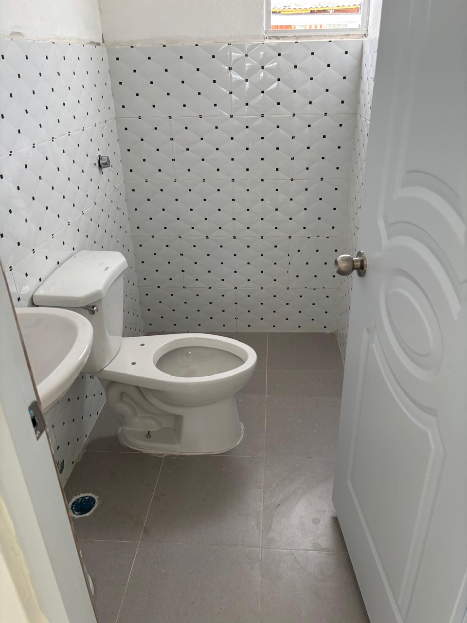 Nuevo baño completo con azulejos, inodoro y lavamanos